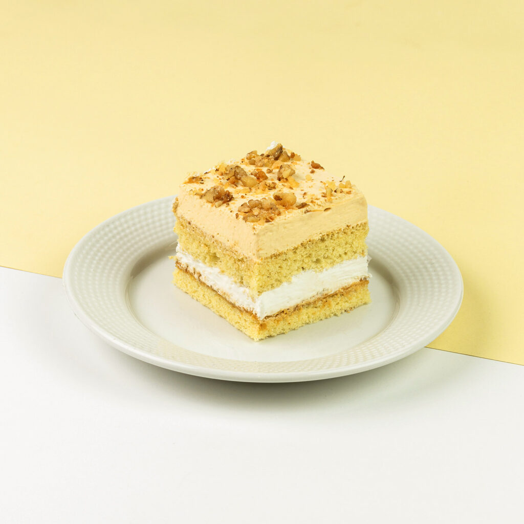 Biszkopt połączony z toffi oraz orzechami palonymi na miodzie z delikatną bitą śmietaną