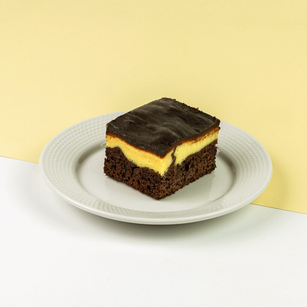 Połączenie ciasta czekoladowego oraz delikatnego sera, całość polana ciemną czekoladą