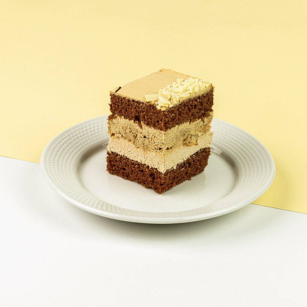 Czekoladowy biszkopt przełożony kremem budyniowym na bazie cappucino oraz śmietaną