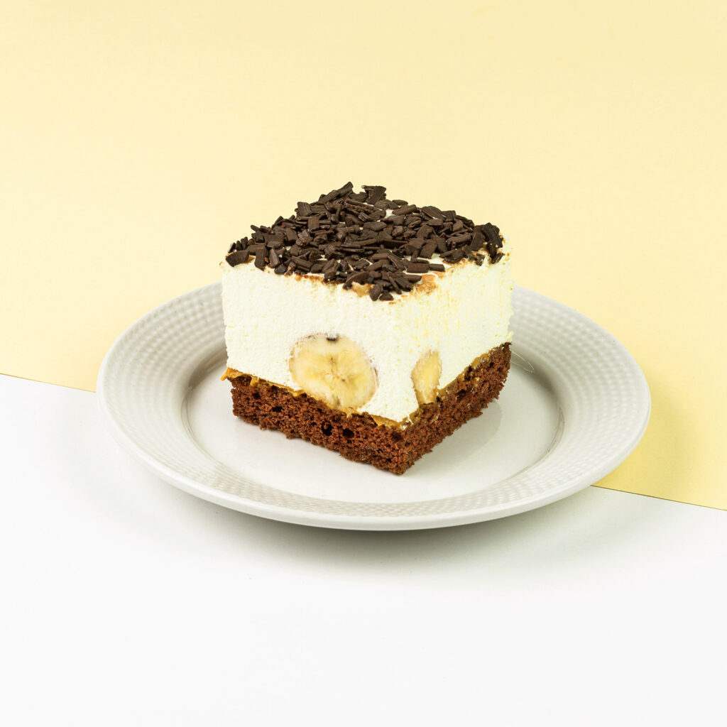 Połączenie biszkoptu czekoladowego, bitej śmietany, kawałków banana oraz czekolady