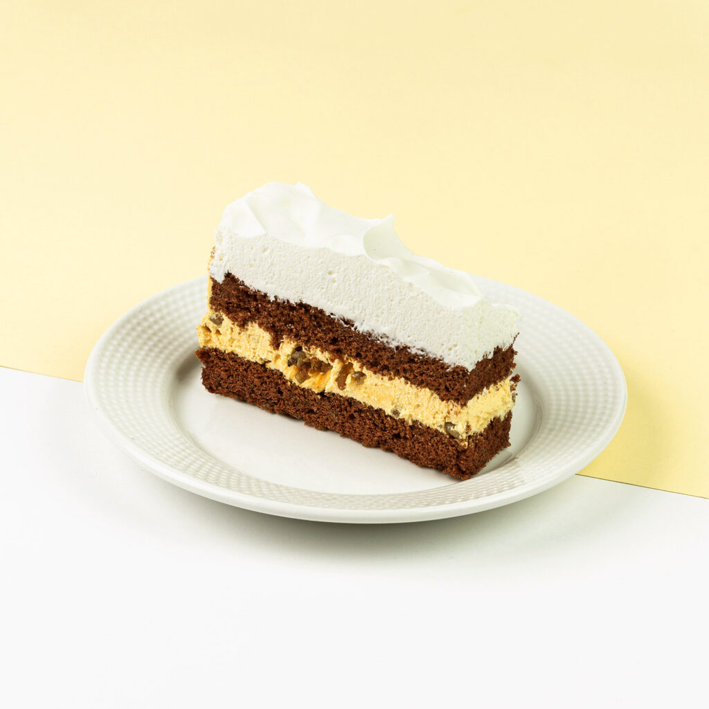 Ciasto czekoladowe połączone z kremem toffi z dodatkiem słonecznika, wykończone bitą śmietaną