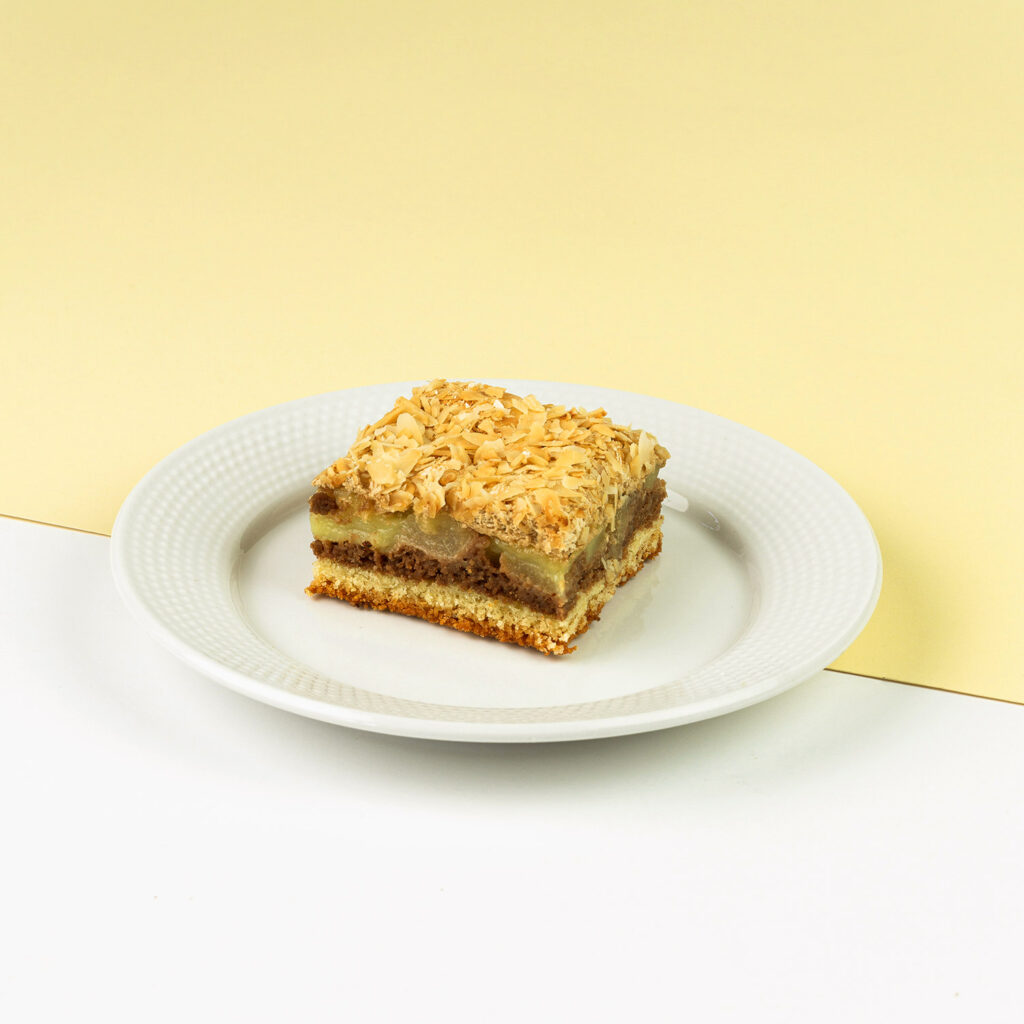 Ciasto migdałowe z dodatkiem gruszki, dekorowane bezą i migdałami