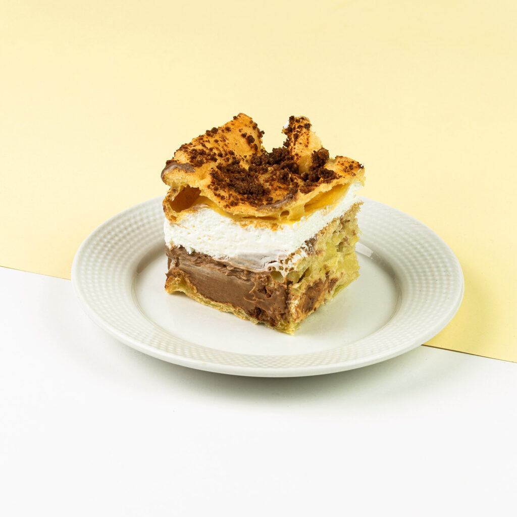 Ciasto parzone z kruszoną czekoladą przełożone bitą śmietaną oraz budyniem czekoladowym