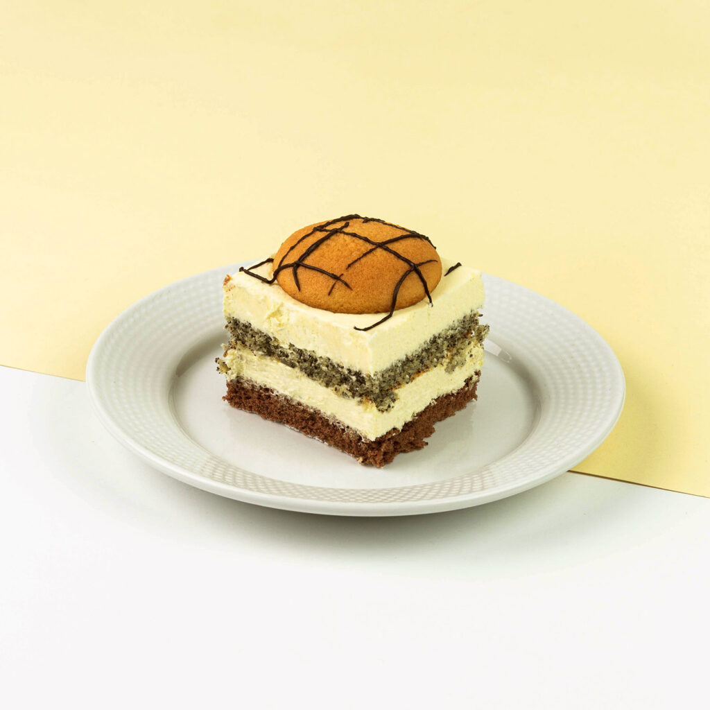 Ciasto makowo - kokosowe przełożone kremem śmietankowym, wykończone ponczowanymi alkoholem biszkoptami