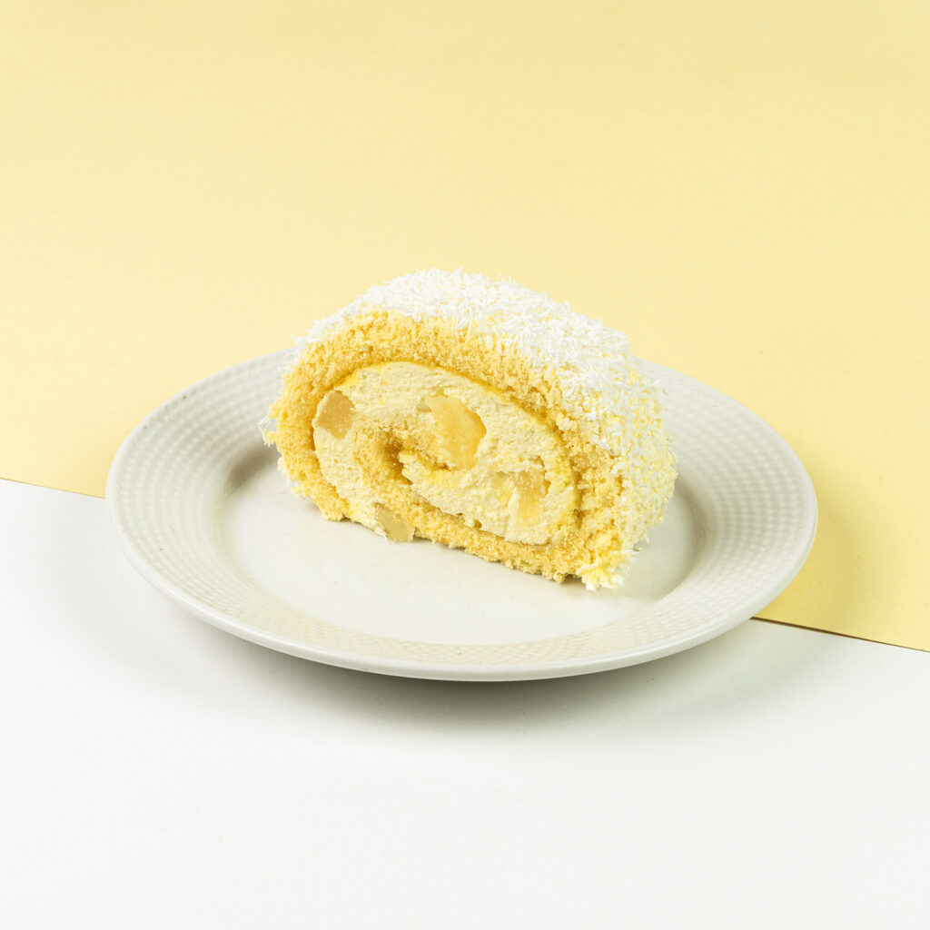 Masa z dużymi kawałkami ananasów owinięta puszystą roladą biszkoptową