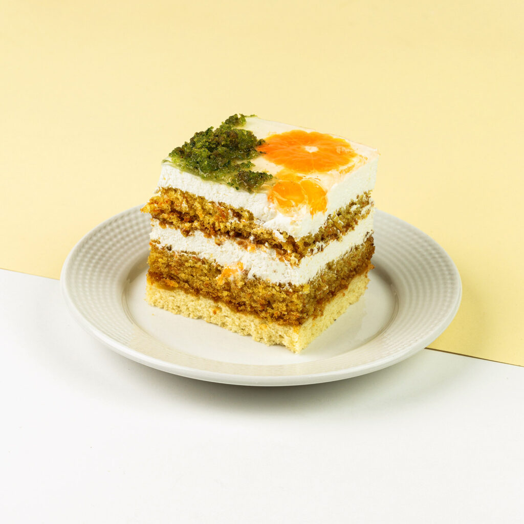 Marchewkowe biszkopty przełożone bitą śmietaną z białą czekoladą, wykończone pomarańczą