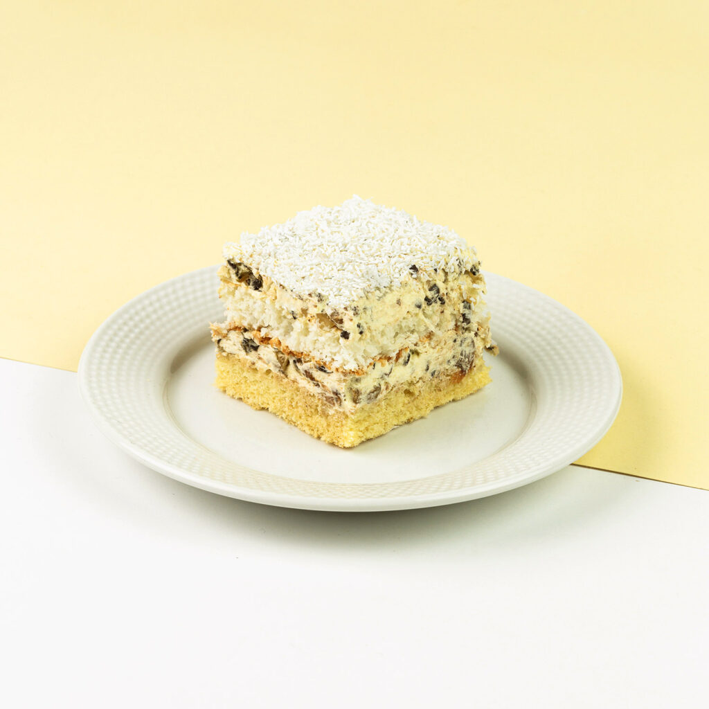 Delikatny biszkopt przełożony kremem kokosowym z dodatkiem czekolady oraz rodzynek