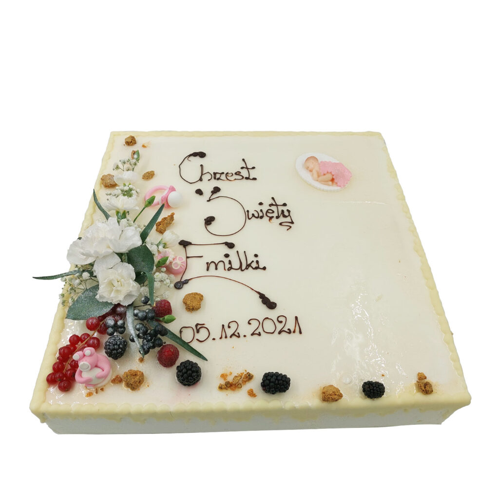 Prostokątny tort z czekoladowym napisem Chrzest Święty Emilki ozdobiony białymi kwiatami oraz jeżynami, malinami, czerwonymi porzeczkami. Zdobienie w postaci małego biało-różowego smoczka, biało-różowej żabki oraz biało-różowej śpiącej dziewczynki.