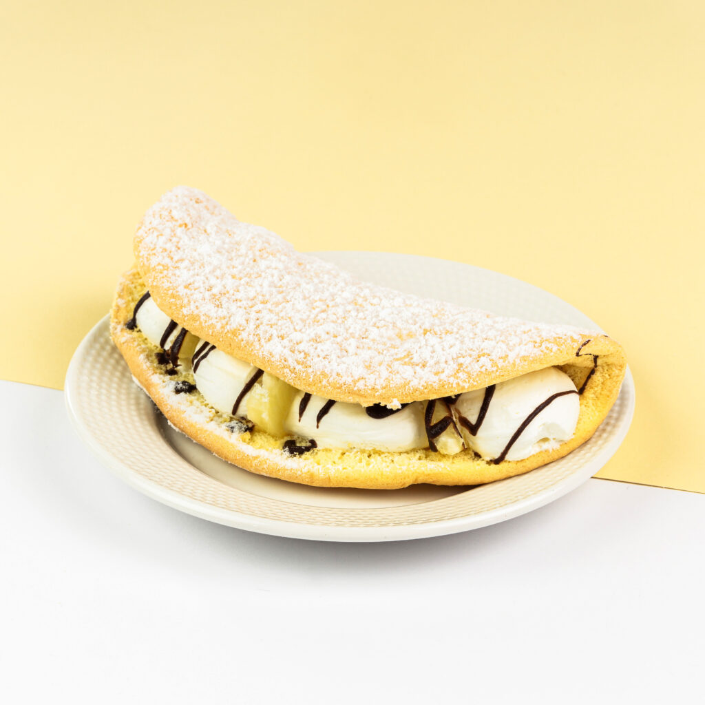 Delikatne ciasto biszkoptowe z bitą śmietaną, czekoladą, ananasem i dżemową niespodzianką w środku.