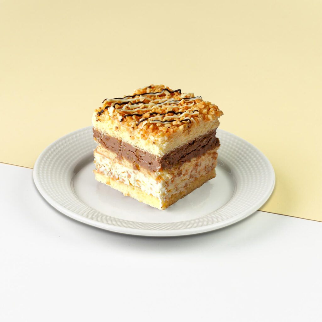 Śmietankowy biszkopt przełożony kremem śmietankowym z mascarpone oraz z białą i ciemną czekoladą z dodatkiem orzechów arachidowych